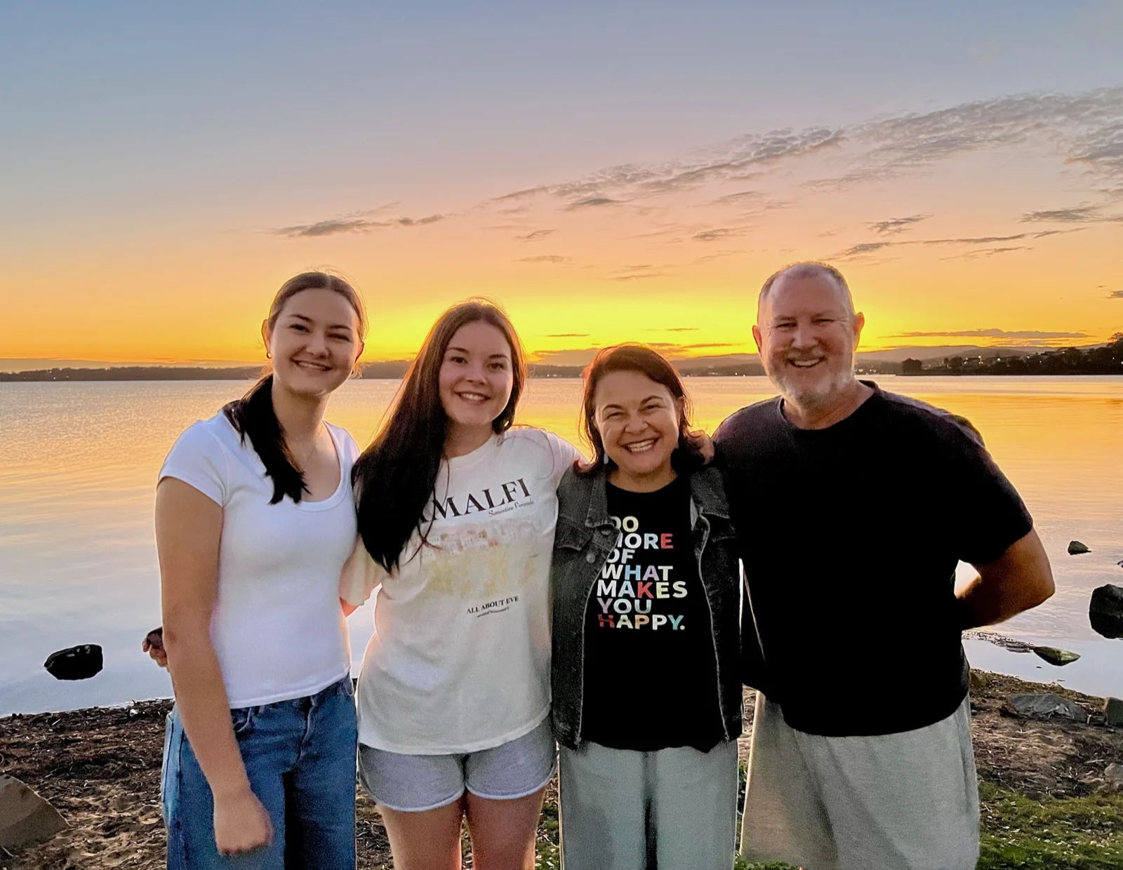 Angela with her family by the lake at sunset.