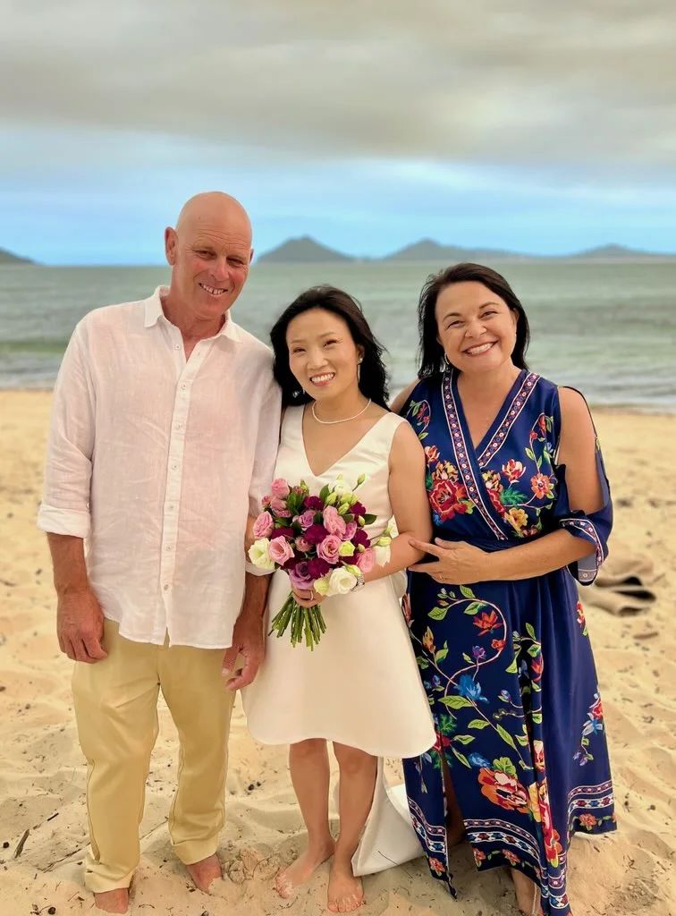 Angela with a wedding couple on the beach.