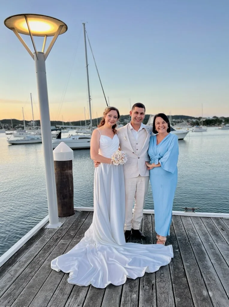 Angela with a couple on a marina jetty at sunset.