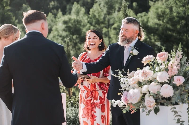 Angela leading an outdoor garden wedding ceremony.