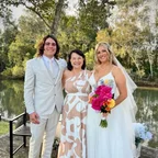 Angela with a newly married couple beside a pond.