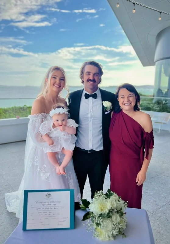 Angela with a couple and their baby at the signing table.