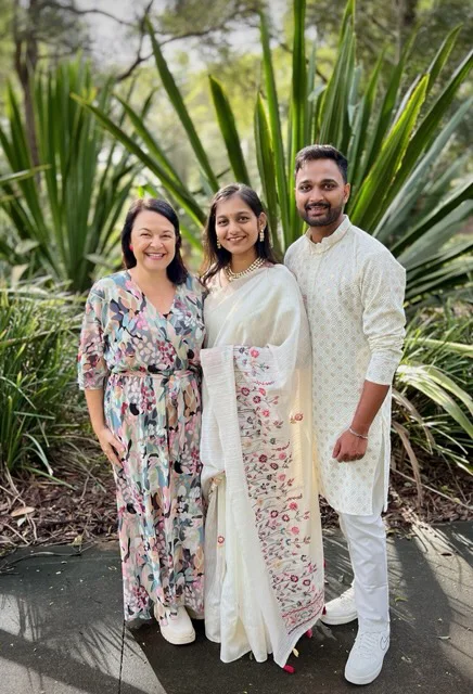 Angela with a wedding couple among tropical plants.